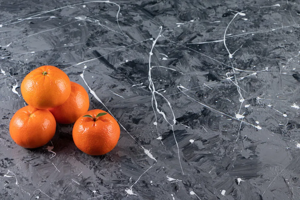 Kamień na blacie kuchennym w kuchni obok mandarynek